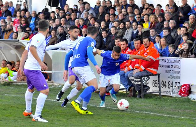 Kevin y Chomfli saliendo de la presión de Mario Martos en el derbi contra el Jaén en Linarejos. /ENRIQUE