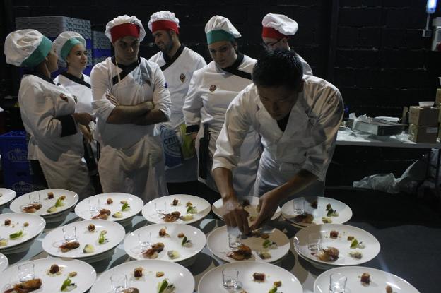 Los alumnos de la escuela observan y comentan el emplatado que realiza el chef japonés Kosei Takakura./J.L. MATARÍN