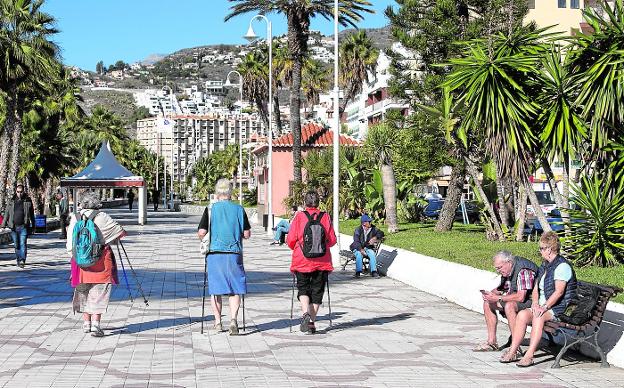 Turistas practicando la denominada 'marcha nórdica', una imagen habitual del paseo de San Cristóbal de Almuñécar en estas fechas./JAVIER MARTÍN