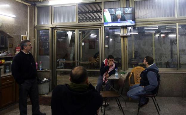 Palestinos siguen por televisión un discurso de Mahmud Abás./Alaa Badarneh (Efe)