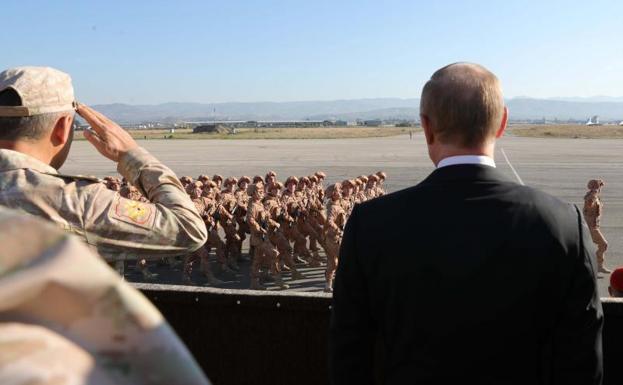 El presidente ruso, Vladimir Putin (d), y el ministro de defensa ruso, Sergei Shoigu (i), visitan la base aérea de Hmeymin, en Siria./Michael Klimentyev (Efe)