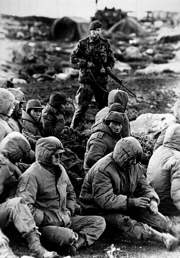 Un soldado custodia a prisioneros argentinos durante la guerra de las Malvinas. /M. CLEAVER