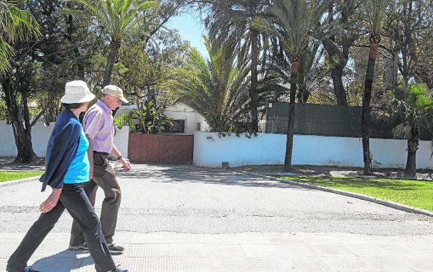 Dos personas pasean frente a la finca Villa Astrida, que ha conseguido el primer informe favorable para ser un hotel. /JAVER MARTÍN