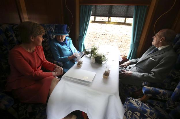 La reina Isabel, con su marido el duque de Edimburgo y la primera ministra escocesa, Nichola Sturgeon, el pasado martes en un tren./REUTERS