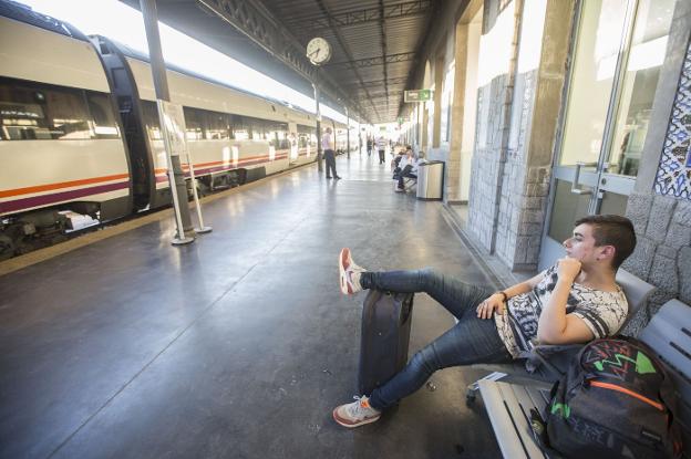 Un chico espera en la estación de Granada, en la que los viajeros de Almería deben transbordar a los buses para seguir su camino hacia Antequera, Osuna, Dos Hermanas y Sevilla./ALFREDO AGUILAR