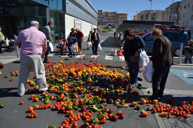 Clientes del supermercado se apresuran a recoger productos arrojados en la protesta de Coag. /IDEAL