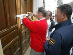 INVESTIGACIÓN. Agentes de la Policía Nacional precintan la puerta de la casa. /FRANCIS J. CANO/