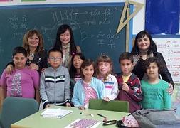 La directora del centro, la profesora y la delegada de Educación, con alumnos de chino. :: IDEAL/