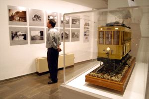 MUESTRA. Un visitante admira las fotografías de trenes; a su espalda, una maqueta del tranvía granadino. /IDEAL/