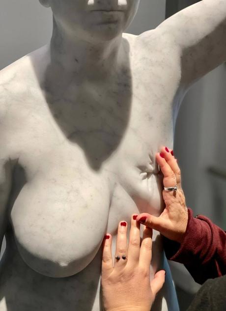 The artist touches the lost chest, in the marble sculpture.  Photo: Salvador Illescas